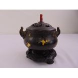 A Chinese bronze incense burner of bellied cylindrical form with side handles and pierced pull off