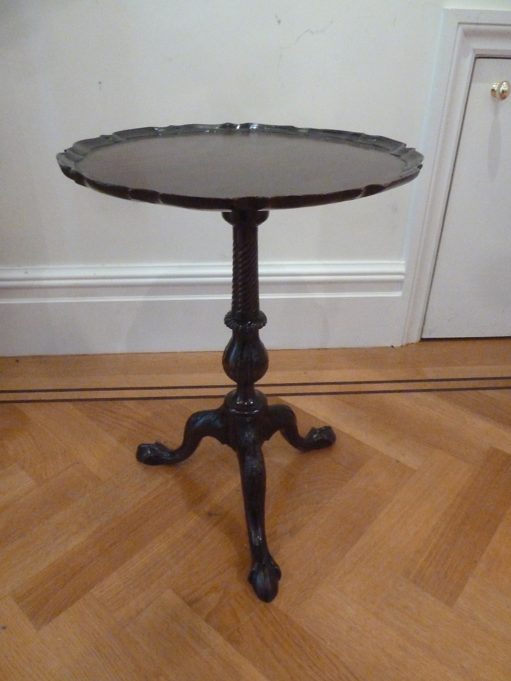 A mahogany side table with pie crust circular border with baluster stem on outswept legs