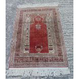 Persian style wool carpet with repeating geometric design and border and central red medallion,