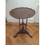 A mahogany tea table circular Chippendale style border on three outswept legs