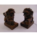 A pair of moulded Dogs of Foe with bronzed finish on raised rectangular plinth