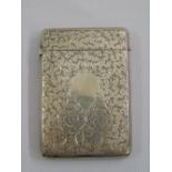 A Victorian silver rectangular card case engraved with leaves and scrolls, with hinged cover,