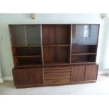 Danish rosewood rectangular three section wall unit with cupboards and drawers on plinth base, to