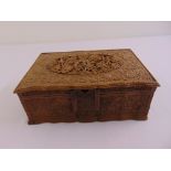 An Indian rectangular jewellery box profusely carved to the hinged cover and sides with flowers,