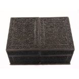 An Indian carved ebony stationery box of rectangular form with profusely carved ides and hinged