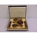 A cased silver gilt and tortoiseshell five piece dressing table set to include two hair brushes, two