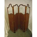 A French mahogany and glazed four panel screen decorated with material panels with stylised leaf and
