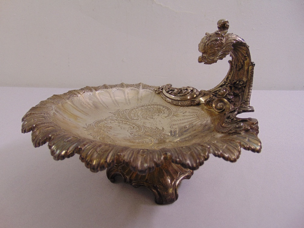 A continental white metal fruit stand in the form of a shell with dolphin handle on four leaf chased