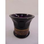 An amethyst glass vase of lobed conical form with a classical gilded band to the base