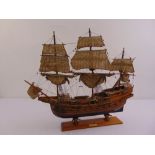 A wooden model of three masted galleon with linen sails on raised rectangular plinth
