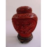Cinnabar lacquered vase and cover carved with scrolls leaves and flowers on hardwood stand