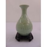 A Chinese pear shaped celadon vase on carved hardwood stand