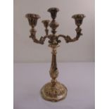 A continental mid 19th century white metal three branch candelabrum, florally chased baluster