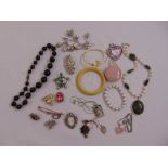 A quantity of costume jewellery to include brooches, bangles and necklaces