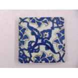 A 17th century Iznik ceramic tile with stylised scroll and floral motif