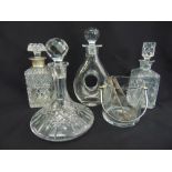 Four cut glass decanters of varying form and an ice bucket with ice tongs and a swing handle