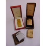 Three gold plated cigarette lighters two in original case and a silvered cigarette lighter (4)