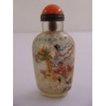 A Chinese reverse glass snuff bottle decorated with figures riding a dragon