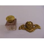 A brass cast cupid mount and an inkwell with hinged cover, A/F