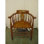 A Victorian blonde oak occasional chair with turned spindles, scrolling arms on turned cylindrical