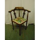 A Victorian oak corner chair with pierced slats, upholstered seat and four turned cylindrical legs