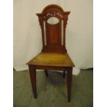A 19th century mahogany hall chair with pierced architectural back on four tapering rectangular