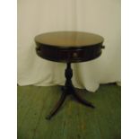 A mahogany circular drum top table with two drawers on three outswept legs with brass castors