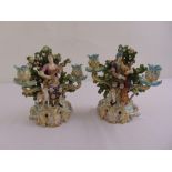 A pair of continental porcelain two light candelabra in the rococo style on raised pierced bases A/