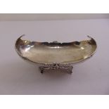 A silver bonbon dish, oval with scroll sides on four leaf supports, Birmingham 1913