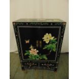 A Chinese rectangular black ebonised cabinet decorated with butterflies, flowers and leaves