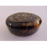 An oval tortoiseshell box with applied white metal plaque
