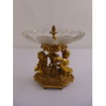 A gilt metal and glass fruit stand, supported by two putti on raised shaped oval base A/F