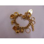 9ct yellow gold charm bracelet with twelve charms and a gold plated padlock, approx total weight
