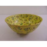 A Chinese yellow ground bowl decorated with flowers and leaves