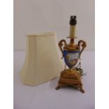A Sevres vase form gilt metal table lamp with scrolling side handles on raised square base with claw
