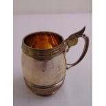 An American late 19th century silver mug, barrel form, scroll handle and gilt wash interior