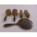 A five piece silver and tortoiseshell dressing table set, comprising a hand mirror, a pair of
