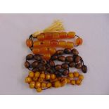 Two amber bead necklaces and a wooden bead necklace of varying colour
