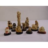 A quantity of oriental carved bone and composition netsuke on original hardwood stands (11)