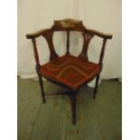 An Edwardian inlaid oak corner chair with pierced slats and turned cylindrical supports