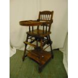 An Edwardian oak metamorphic high chair on four turned cylindrical supports