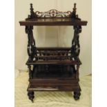 A Victorian mahogany rectangular whatnot cum magazine rack with pierced scroll sides on four bun