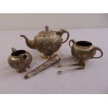 An Indian three piece white metal teaset, with elephant head handle and spouts, the sides chased