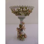 A continental porcelain fruit stand supported by putti on florally encrusted base
