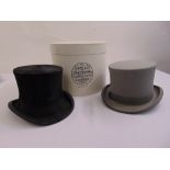 A black silk top hat, a grey felt top hat and a hat box from Lock and Company of St James