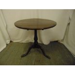 A Georgian mahogany tilt top circular occasional table on three outswept legs