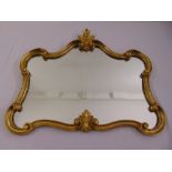 A shaped rectangular gilded wooden wall mirror with shell and leaf motifs