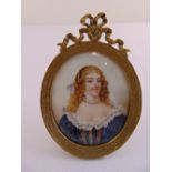 A hand painted miniature of a lady in 18th century costume within an oval gilt metal frame signed