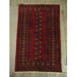A Persian wool carpet red ground with repeating geometric pattern and border, 121 x 79cm