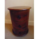 A cylindrical mahogany three drawer side table